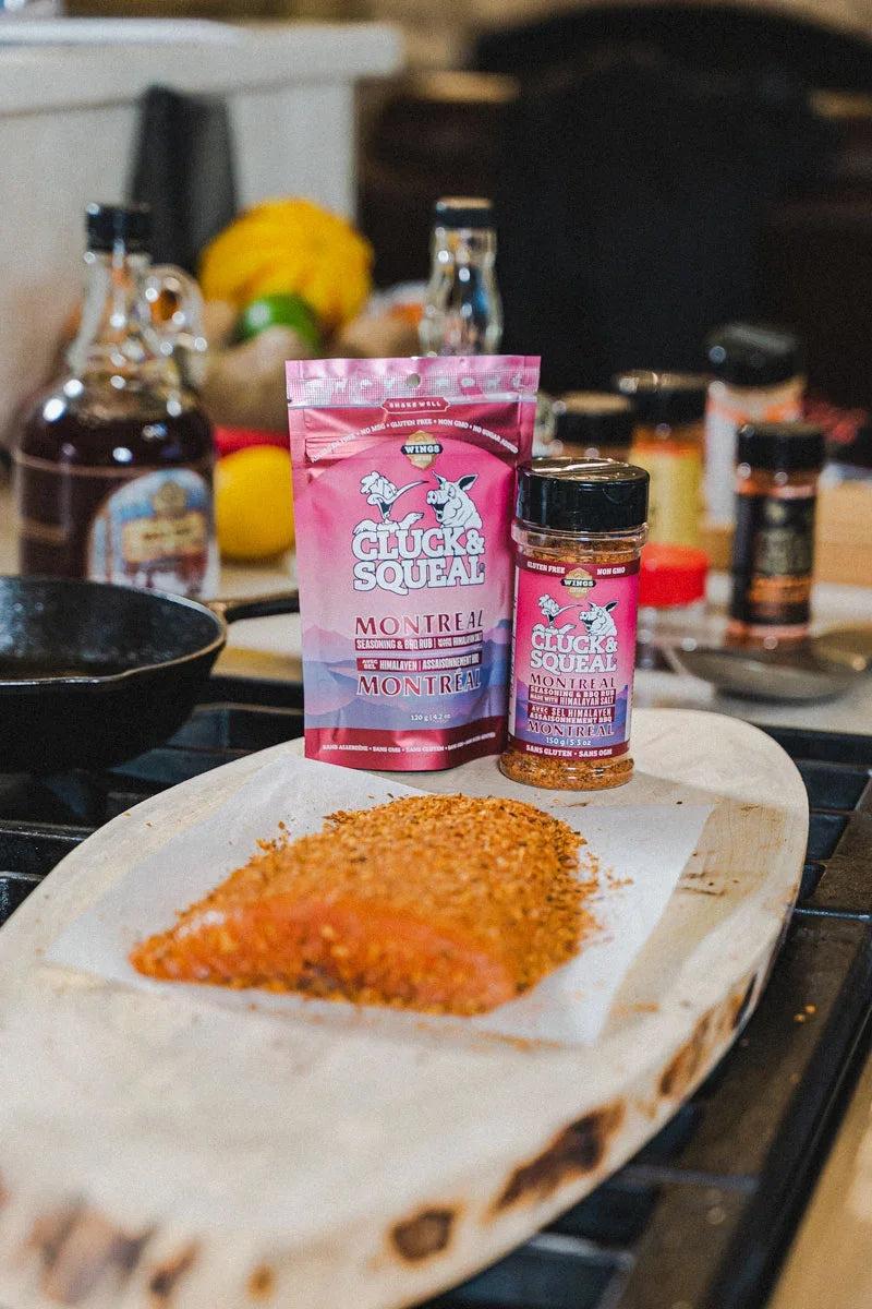 Montreal seasoning rub on salmon, with Cluck & Squeal packaging nearby on kitchen counter